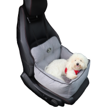 Hvid bomuldshund i en grå autostol til hunde på et sort bilsæde