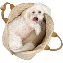 Hvis bomuldshund set oppefra ligger i en sandfarvet hundetaske